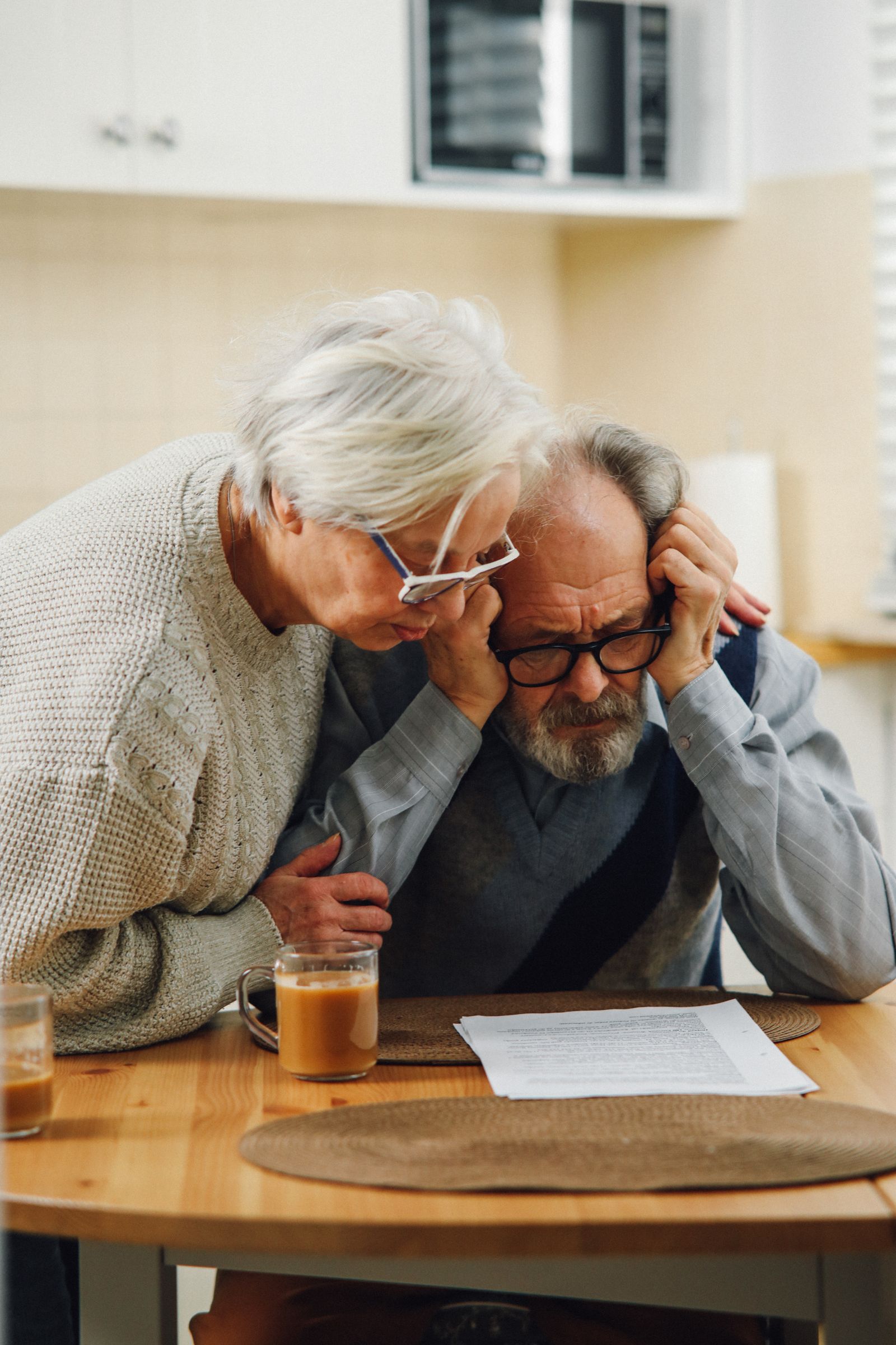 A couple reviewing insurance paperwork at a kitchen table